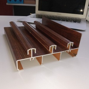 Aluminium schuifdeur- en raamprofielen met houtnerfstructuur, vervaardigd in een Vietnamese aluminiumfabriek.