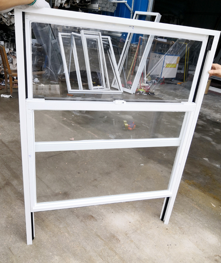Moderne, enkelvoudig hangende, verticale schuiframen voor de keuken met zwart aluminium frame en roestvrijstalen ophangsysteem.