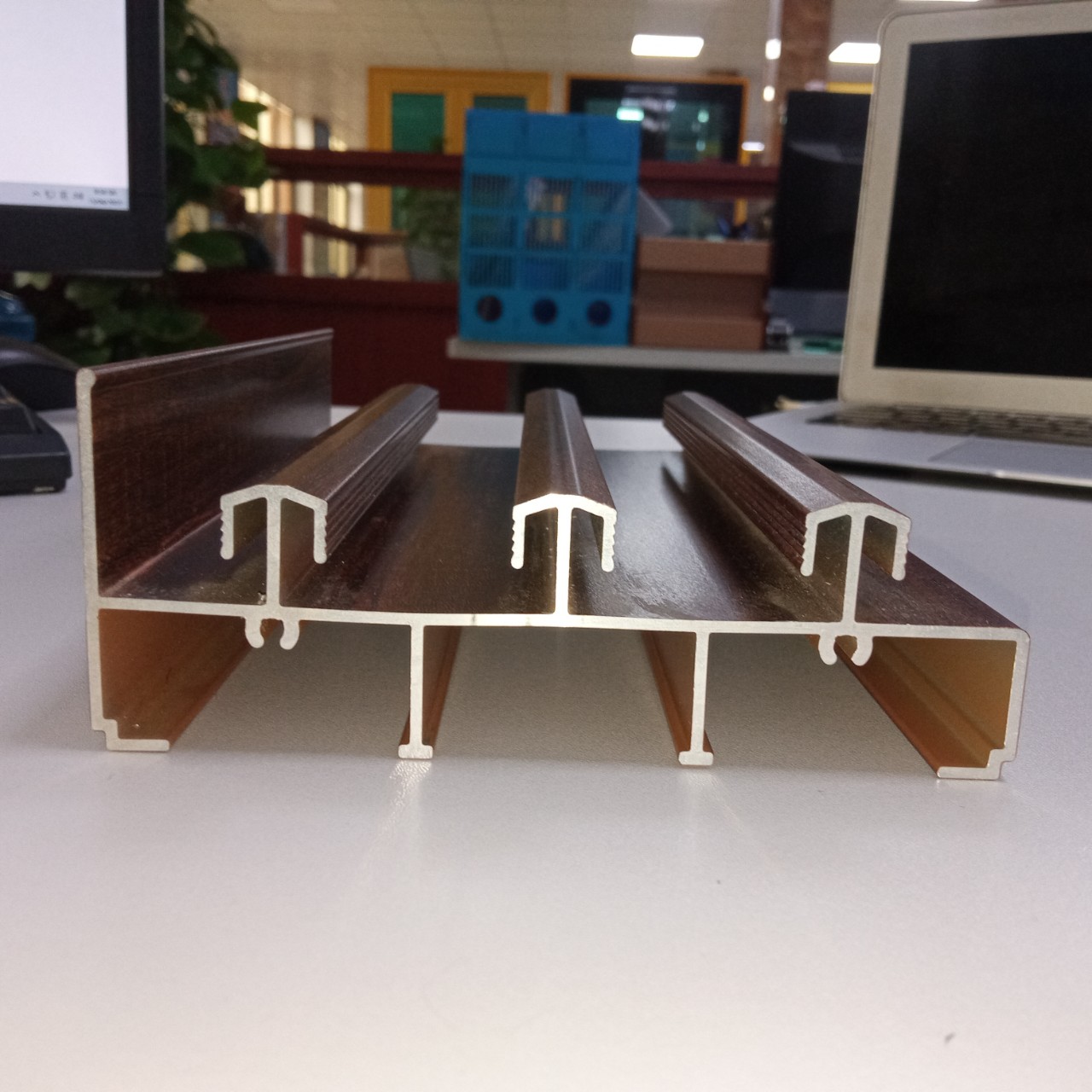 Aluminium schuifdeur- en raamprofielen met houtnerfstructuur, vervaardigd in een Vietnamese aluminiumfabriek.