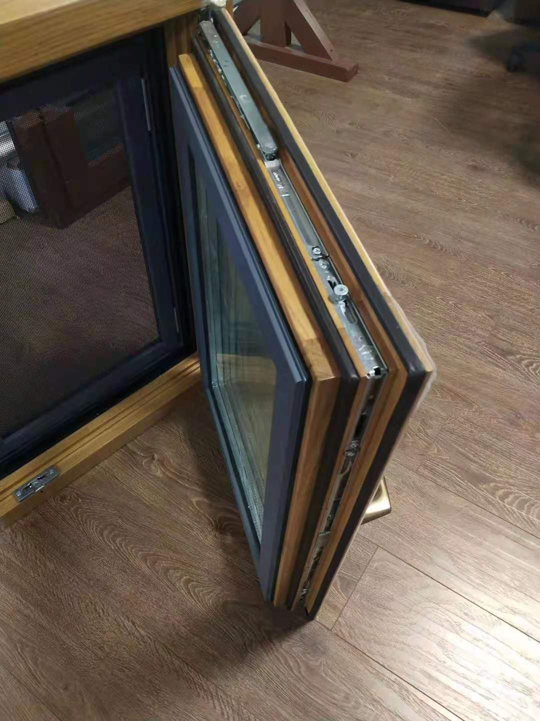 Aluminium beklede houten draai-kiepramen met horren.